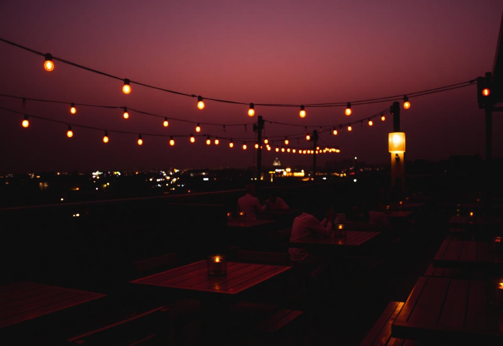 Rooftop restaurant at dusk with warm string lights